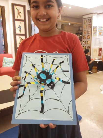 This student is all smiles with her completed 3D spider craft. Paper sculpture projects are fantastic for developing spatial reasoning and fine motor skills in young children.