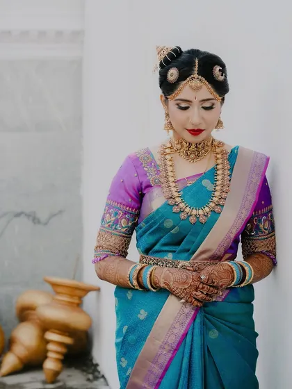Another elegant portrait of the bride, Ananya, showcasing her complete bridal look from her posture to her intricate hair and jewelry.