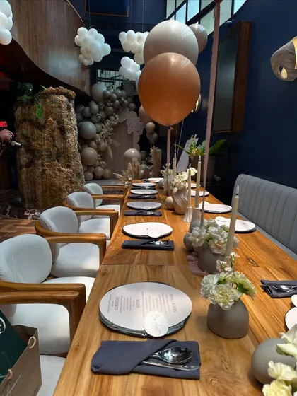 A long view of the dining setup for the "Oh Baby" shower, where clean lines, neutral tones, and minimalist floral arrangements created a feeling of calm elegance.