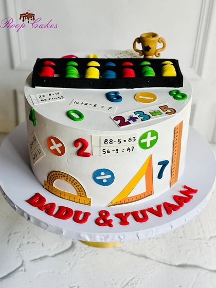 A cake for a little genius. This design is themed around the abacus and mathematics, decorated with numbers, symbols, and an edible abacus topper. It's both fun and educational.