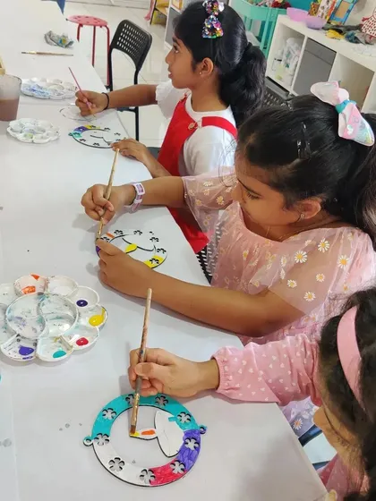 Three girls engrossed in painting their festive Diwali hangings. The concentration and creativity are wonderful to see.