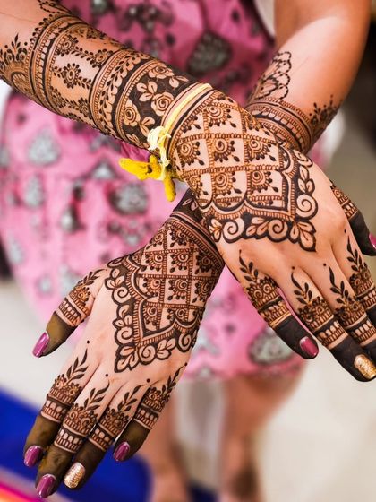 The back of the hands, adorned with intricate swirls and leaf patterns, perfectly complementing the detailed arm bands.