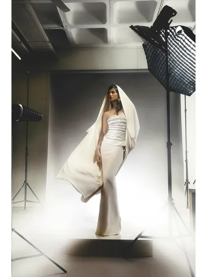 A behind-the-scenes style shot from a studio session. The dramatic lighting and the visible equipment highlight the process of creating a high-fashion image with a full studio setup.