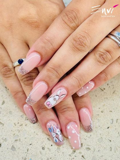A playful and cute design featuring hand-painted bunnies and polka dots on a pink base with glittery French tips. This shows my ability to create fun, themed nail art for any occasion.
