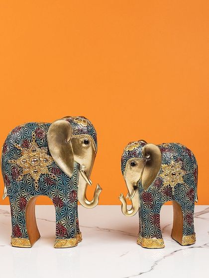 This pair of standing elephants features a unique, modern pattern in shades of blue, red, and gold. They are a contemporary take on a classic symbol, blending artistry with tradition.