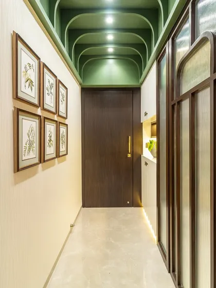 A dose of color can liven up any hallway. The gorgeous green arched ceiling with spotlights draws the eye upward, while a gallery wall of botanical prints adds a touch of nature.