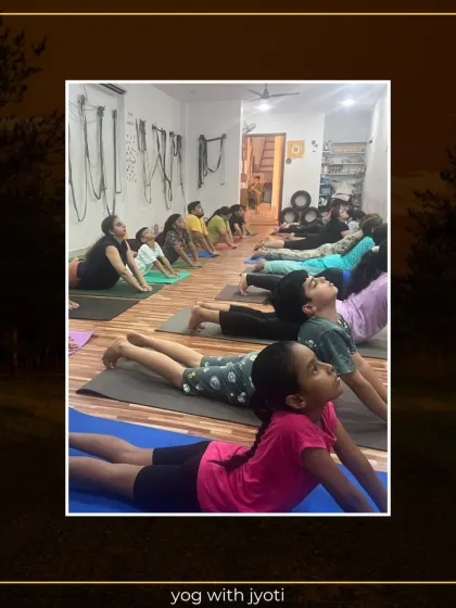A line of students, including children, practicing Bhujangasana together, showing that yoga is a family activity.