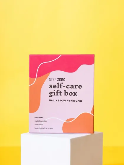 A vibrant shot of the Step Zero self-care gift box on a white pedestal against a bright yellow background. This color-blocking technique makes the product stand out.