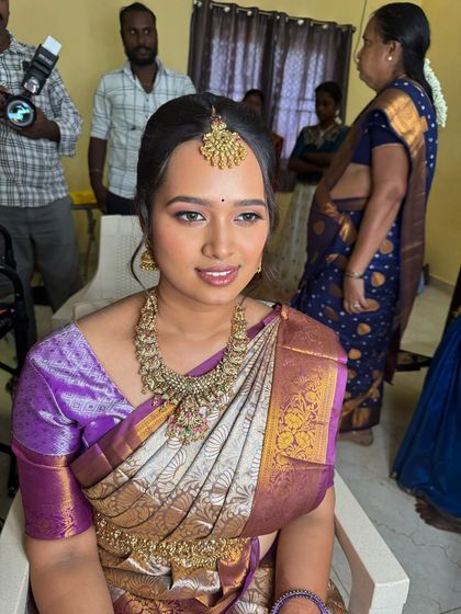 A candid shot of Swathy during her engagement, showing her natural smile. The makeup looks fresh and is designed to last through all the festivities.