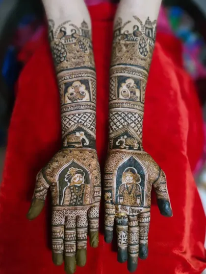 Full view of a traditional bride and groom portrait mehendi. The design extends up to the elbows with classic motifs like peacocks, elephants, and auspicious wedding symbols.