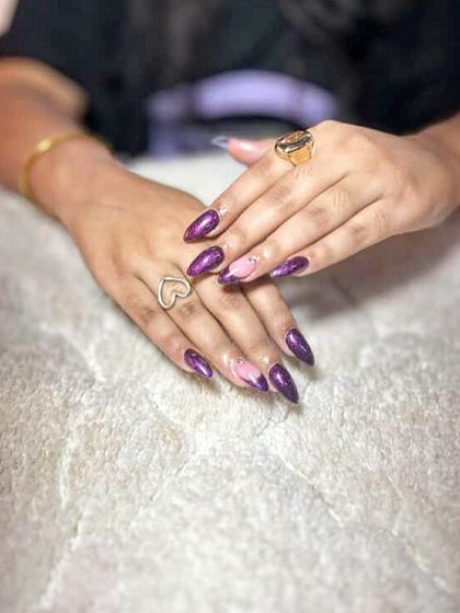 A dramatic purple cat-eye effect with a negative space accent nail. The shimmer and depth in these nails are incredible.