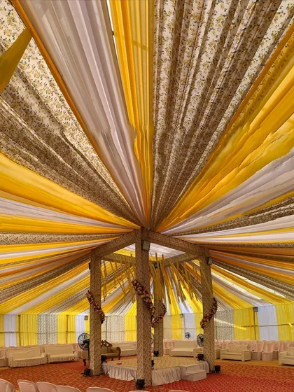 Another perspective of the grand draped Haldi mandap, looking up into the intricate canopy. The radiating lines of fabric create a stunning visual effect.
