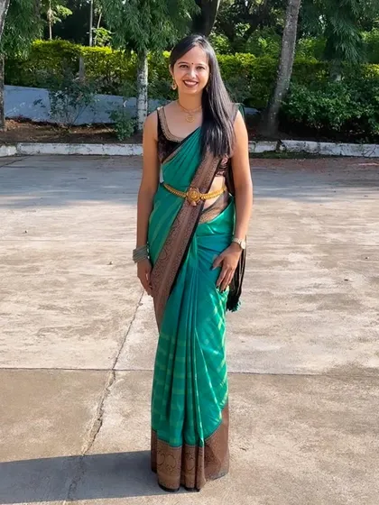 A full-length view of Thanni's modern take on traditional wear, pairing a sleeveless velvet blouse with her beautiful teal Kanjeevaram.