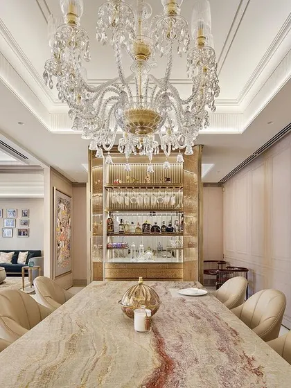 This dining area for an apartment at DLF Camellias is designed for sophisticated entertaining. A sleek bar cabinet acts as both a functional storage unit and a screen, creating an elegant transition to the living area while maintaining an open, fluid layout.