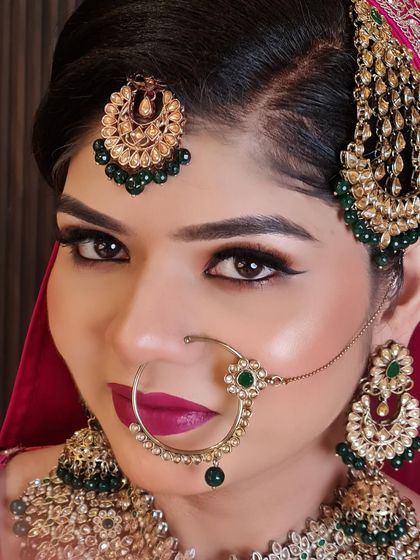 A beautiful close-up. Her winged eyeliner and bold lip are perfectly balanced by the heavy green and gold traditional jewelry.