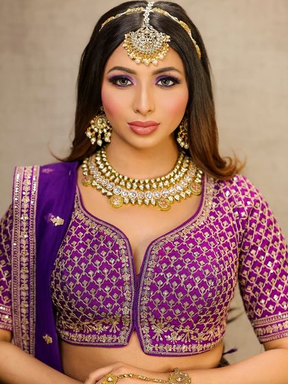 A bold and beautiful look in a purple lehenga. The eyes are the star here, with a dramatic purple smokey effect that is balanced by a neutral lip color.