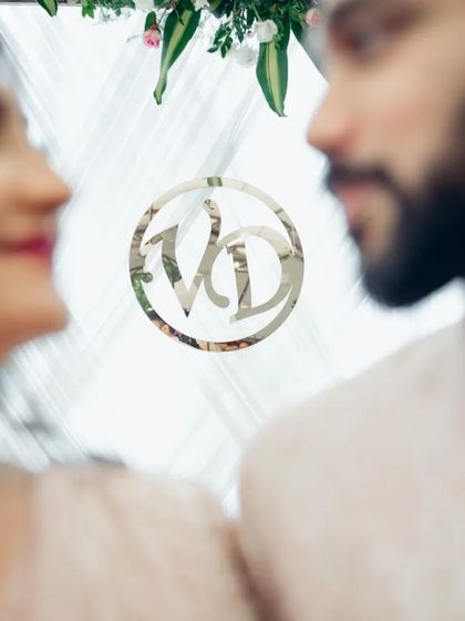 A detail shot focusing on the couple's monogram, with them softly blurred in the background. This highlights the personalized details of their special day.