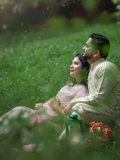 A maternity portrait capturing the glow of the mom-to-be in the rain-soaked greens, with twinkling lights adding a touch of magic.