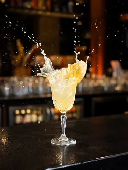 Another dynamic cocktail splash, this time with a yellow cocktail. Capturing the motion and energy like this creates a high-impact visual that's perfect for a bar's promotional content.