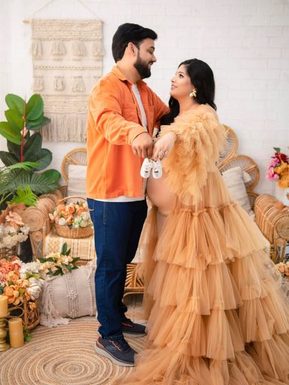A sweet interaction where the couple holds a pair of baby booties together. This simple prop adds a powerful narrative element to their maternity love story.