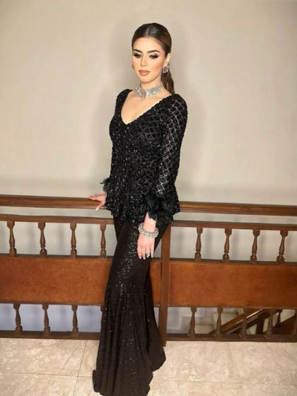 The client looks stunning in her all-black ensemble, with the sleek ponytail adding a touch of sharp elegance.