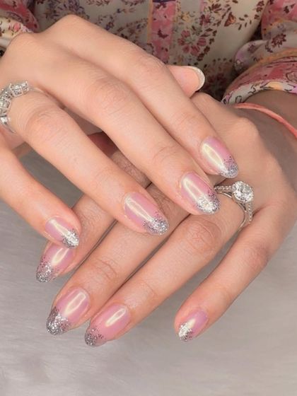 A hint of glitter. A sheer pink manicure with a simple, sparkling silver glitter French tip.
