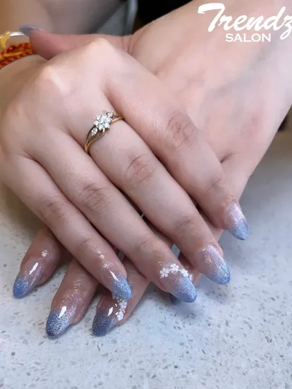 Perfect for summer, this design features a sparkling blue glitter ombre on long, clear extensions. I added delicate, hand-painted white flowers for a fresh and vibrant finish.