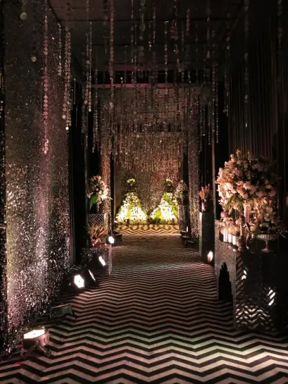 We believe the guest experience begins at the entrance. For this glamorous black and silver themed Sangeet, we designed a dramatic entryway with a chevron-patterned floor and shimmering crystal curtains, setting the stage for an unforgettable night of music and celebration.