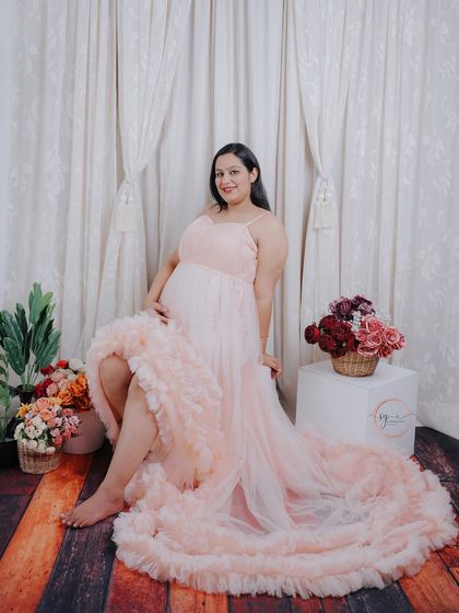 A beautiful full-length portrait showcasing the stunning details of the ruffled gown. The soft lighting creates a dreamy and romantic feel.