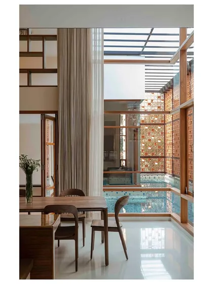 In this residence, the lap pool is integrated into the core of the house, acting as a natural climatic device. It helps cool the adjacent dining and living areas through evaporative cooling while creating a stunning visual centerpiece that reflects light throughout the space.