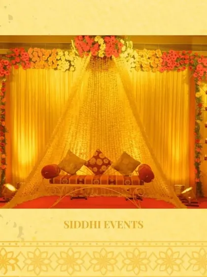 A glorious Haldi decor setup featuring a canopy of marigold strings, creating a tent-like structure over the seating area for a traditional and immersive experience.