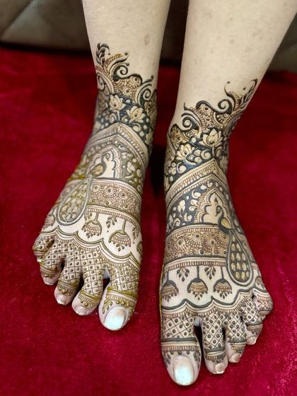 A full-coverage bridal foot design with classic Indian motifs like peacocks, elephants, and jhumkas, perfectly mirroring a bridal hand design.
