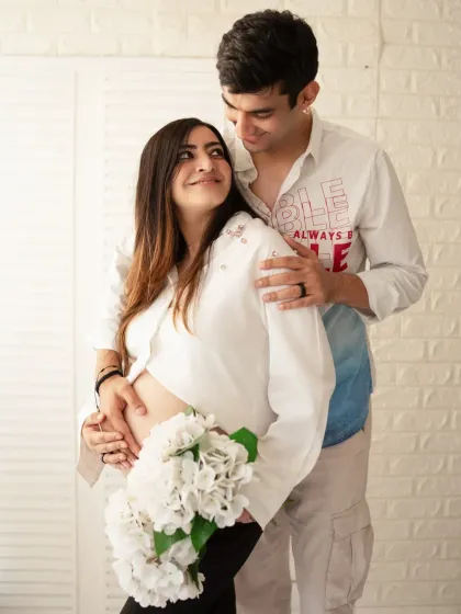 A bright and happy couple's portrait. The expecting parents share a loving gaze in a high-key studio setting, creating a fresh and joyful image.