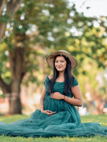 A relaxed, seated portrait in our teal maternity gown. The soft tulle spreads out on the grass, creating a beautiful composition for a peaceful outdoor photoshoot.
