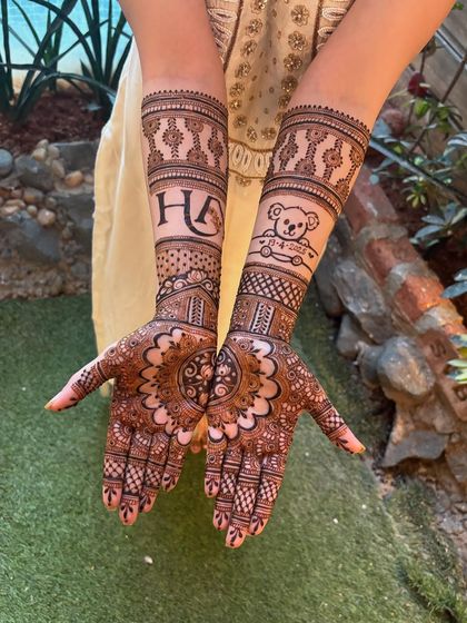 A clear shot of the personalized bridal mehendi, showing the "HA" initials and the cute teddy bear with the special date.