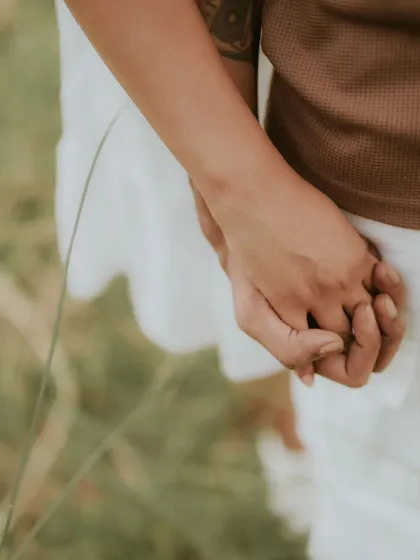 A close-up of a couple holding hands, a simple yet powerful symbol of their connection. This detail shot is a beautiful way to capture the intimacy of a relationship.