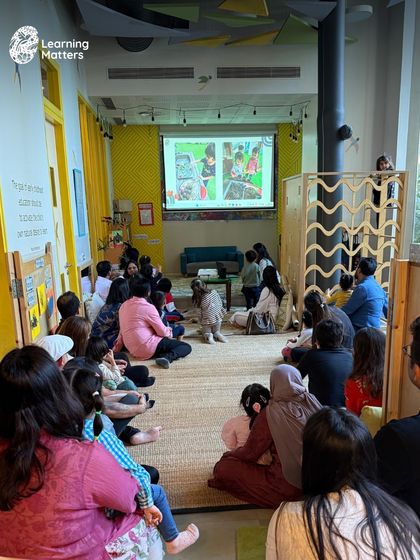 A child stands up, captivated by the images on the screen during our end-of-year celebration at Max Towers. Seeing their own experiences reflected validates their journey and builds their confidence.