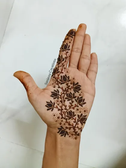 A delicate lotus vine design. The dark-filled flowers create a beautiful contrast, making the pattern pop. This is a great example of Indo-western mehndi.