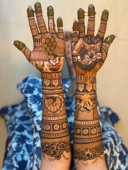 This design shows the back of the hands, featuring peacock and tiger motifs, a less common but powerful choice.