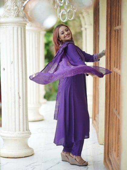 A joyful, twirling shot of the model between the white pillars.