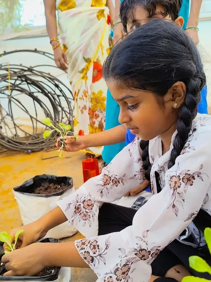 A young participant in our youth program carefully plants a sapling. Since 2020, we have educated over 1500 children on sustainable food systems, food security, and regenerative agriculture.