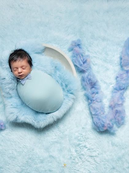 A portrait that spells out what it's all about: LOVE. The baby is peacefully sleeping while surrounded by the word spelled out in fluffy blue wool.