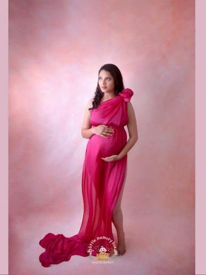 A full-length portrait showing the gorgeous flow of the pink fabric. This technique helps create a sense of elegance and movement in the maternity photo.