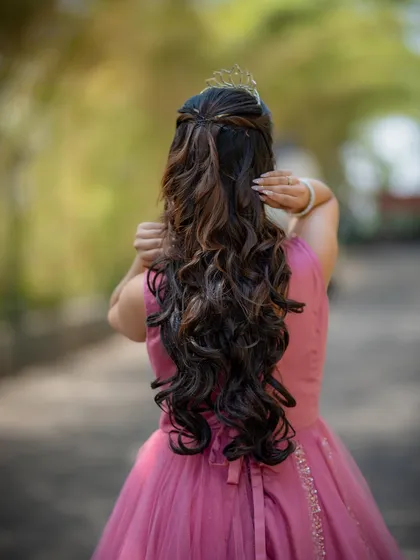 A view of the back of a gown hairstyle, featuring long, flowing curls perfect for a princess look.