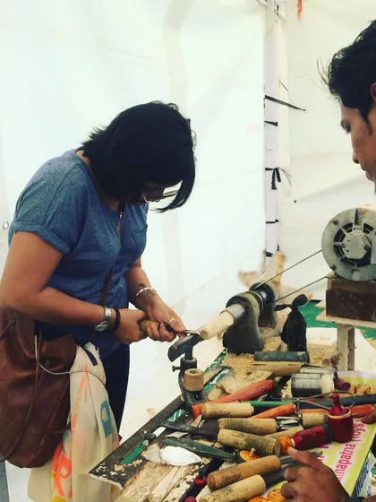 An artisan watches closely as a visitor carefully carves a piece of Ivory wood. Our workshops are designed to be a collaborative and supportive learning environment, where we share the joy of our craft.
