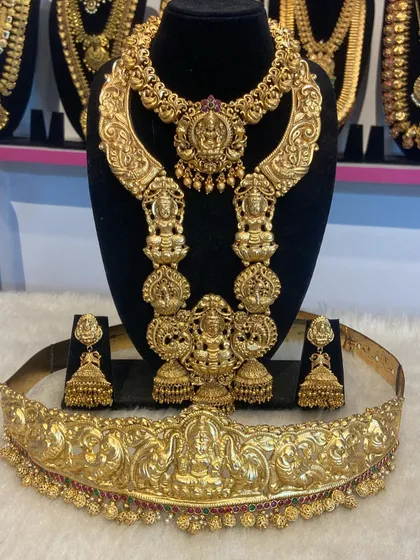 An exceptionally grand bridal set with bold, sculptural elements. This set includes a wide choker, a matching haram, and a full vaddanam, all with detailed temple carvings.