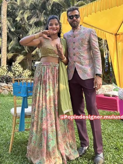 A fun and happy client couple at a mehendi function. Her printed lehenga is perfectly complemented by his stylish bandhgala jacket.