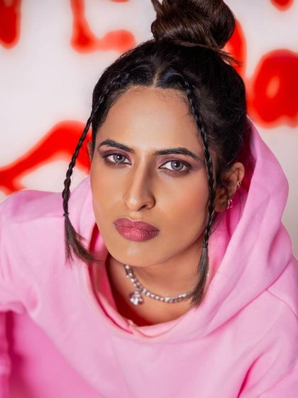 A close-up portrait from the graffiti shoot, focusing on the model's confident expression and modern styling. The vibrant red and pink tones make the image pop.