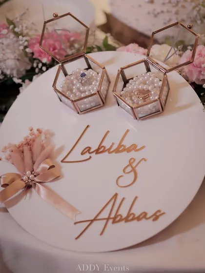 A beautifully crafted custom ring platter for Labiba & Abbas. The design features rose-gold hexagonal boxes on a bed of pearls, showcasing our attention to personalized, luxurious details.