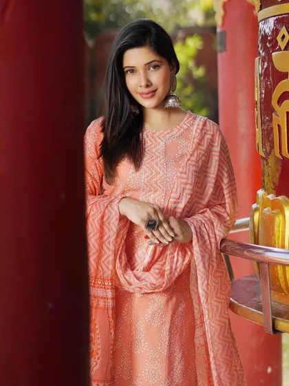 A close-up of this peach printed kurta set, showing how simple silver earrings and a statement ring can complement the outfit without overpowering it. It's all in the details.